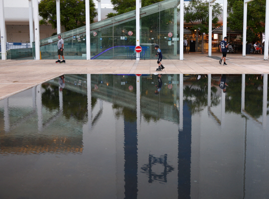 이란의 보복 공격이 임박한 가운데 12일(현지시간) 이스라엘 텔아비브에서 한 소년이 분수옆에서 인라인 스케이트를 타고 있다.   <로이터연합>